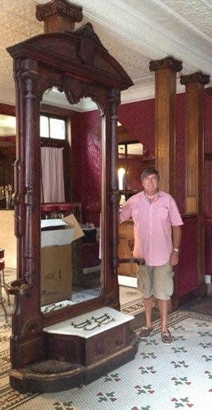 Auctioneer Tim Chapulis is dwarfed by a monumental marble-top hall tree standing 9 1/2 feet tall. Tim’s Inc. image.